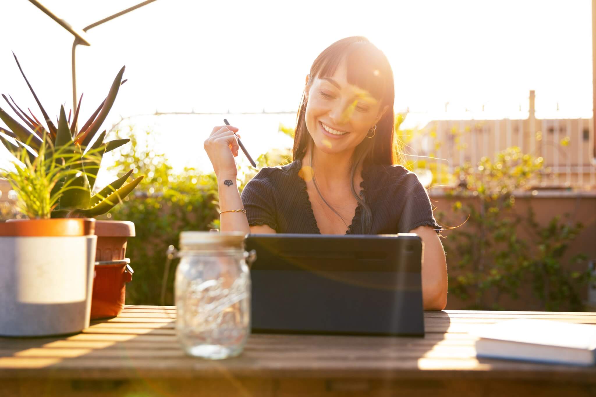 Young woman using tablet on terrace at sunset Young woman using tablet on terrace at sunset - Experience Rye Ranch from Anywhere: Virtual Tour Now Available for Southwest Florida’s Newest Home Community