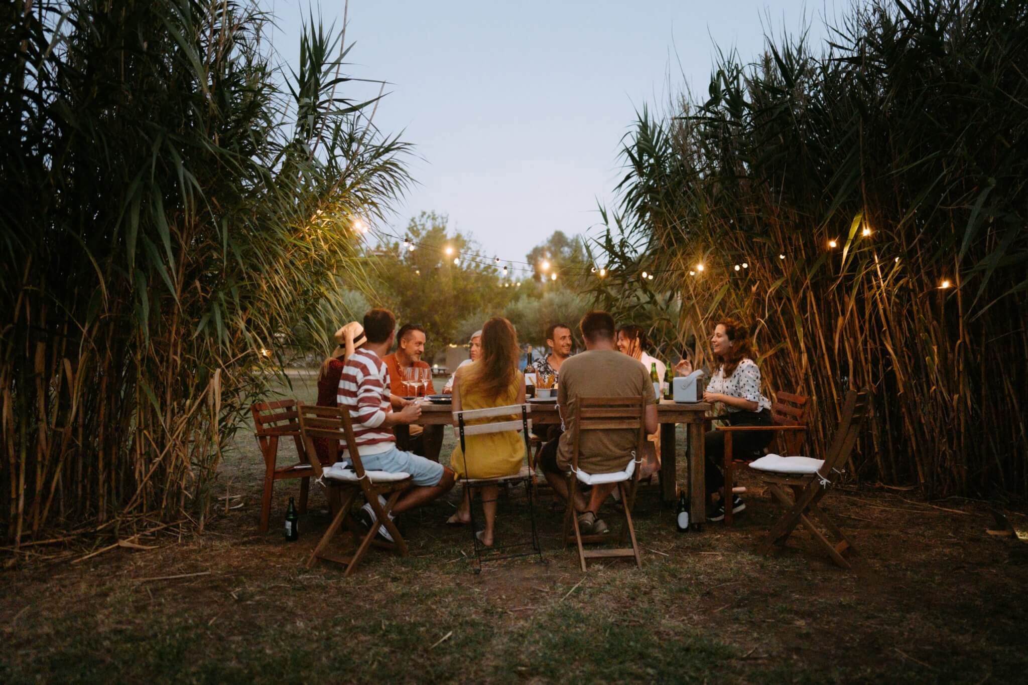 Photo of a small group of friends enjoying the summer dinner party outdoors.