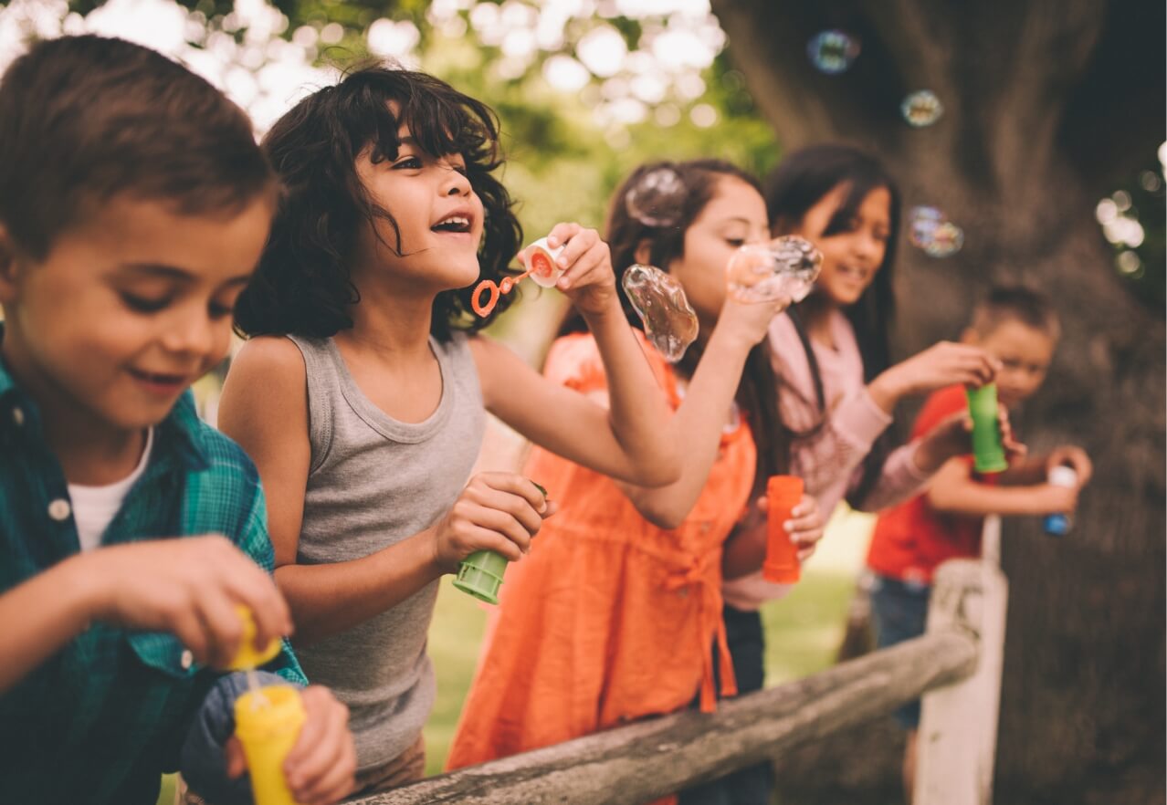 children blowing bubbles outside