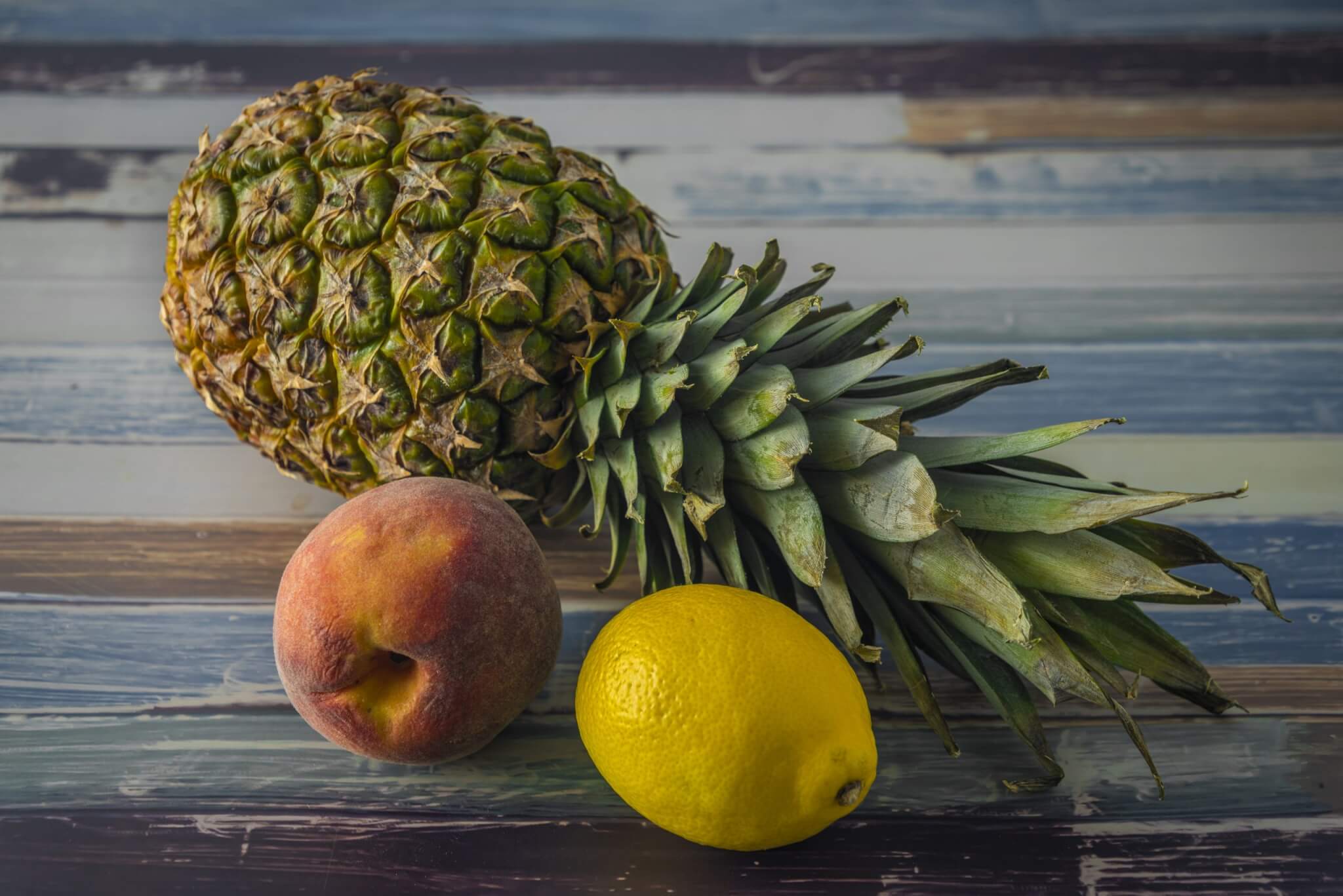 Exotic color fresh fruit on old blue table with side day light - Sparkling Pineapple Peach Lemonade