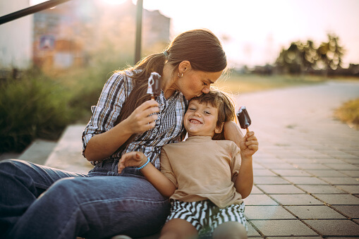 Mother and son having fun in public park, eating ice cream Mother and son having fun in public park, eating ice cream