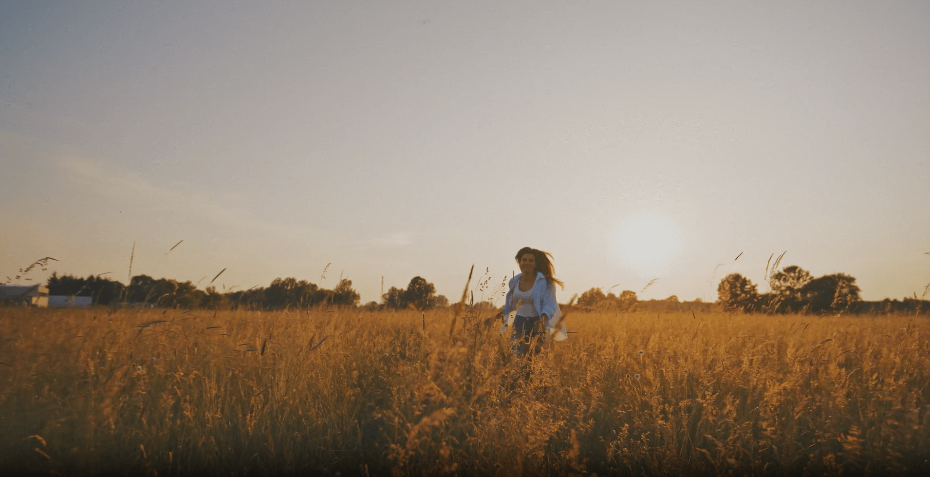 woman running through golden grass