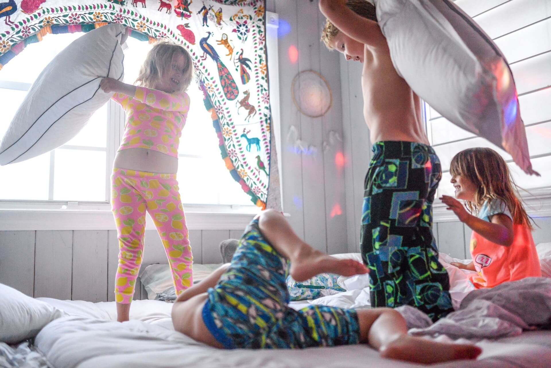Children playing with pillows on the bed