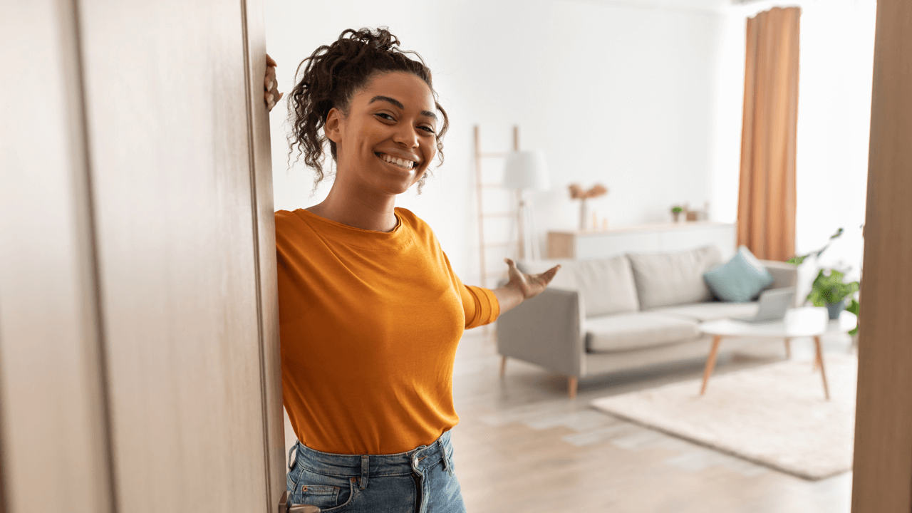 RYE blog post June 17 A young woman with medium-complexion and yellow shirt invites us into her home